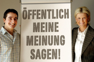 Mann und Frau stehen am Flipchart "Öffentlich meine Meinung sagen!" / Foto: TELOS - 06463r