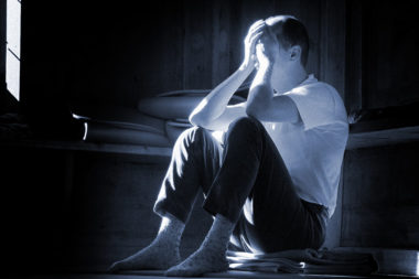 Gefühle Trauer Sorge Mann traurig am Boden sitzen Hände vor Gesicht / Foto: TELOS - 10441bl