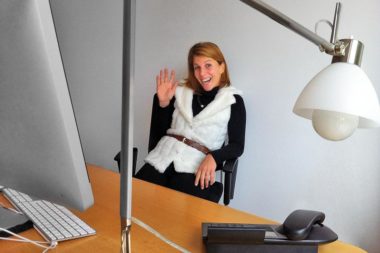 Frau lachen winken Büro Computer Telefon Lampe / Foto: TELOS - iPa7617b