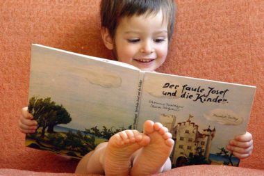 Lesen Bilderbuch lächeln Kind / Foto: TELOS - 05823b