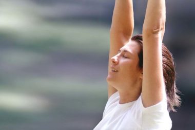 Meditation Outdoor Frau Augen geschlossen Arme hoch / Foto: TELOS - 05721c